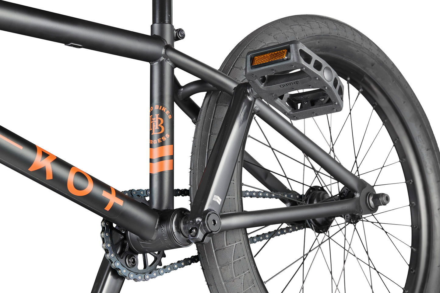 Close-up of the Burgess BMX bike frame, pedal, rear wheel, and chain with orange accents—perfect for advanced riding.