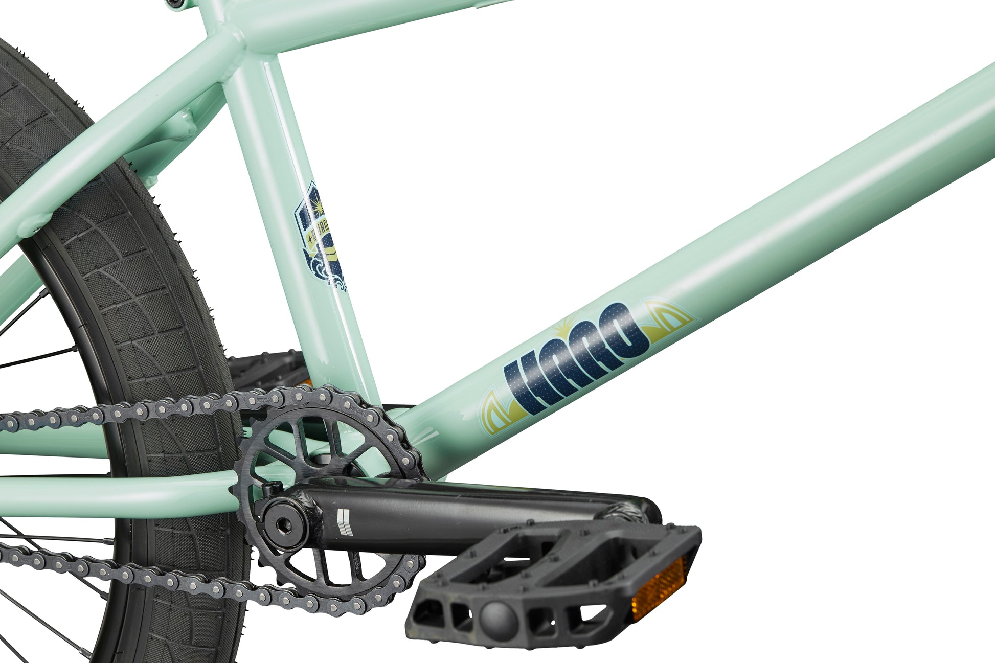 Close-up of the Burgess light green BMX frame with chain, pedal, rear tire, and KINK brand—ideal for advanced riders.