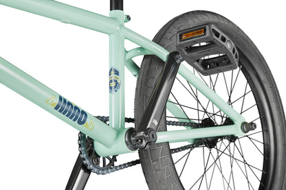 Close-up of the Burgess BMX bike's rear wheel, pedal, crank, and chain highlighting frame details and tire tread.