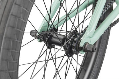 Close-up of the Burgess rear wheel, showing spokes, black hub, chain, and mint green frame.