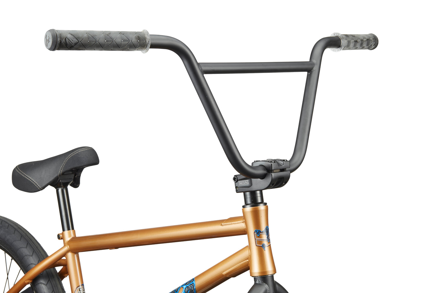 Close-up of Dana bike’s black handlebars and gold frame with a black seat and gray grips in custom colorways.