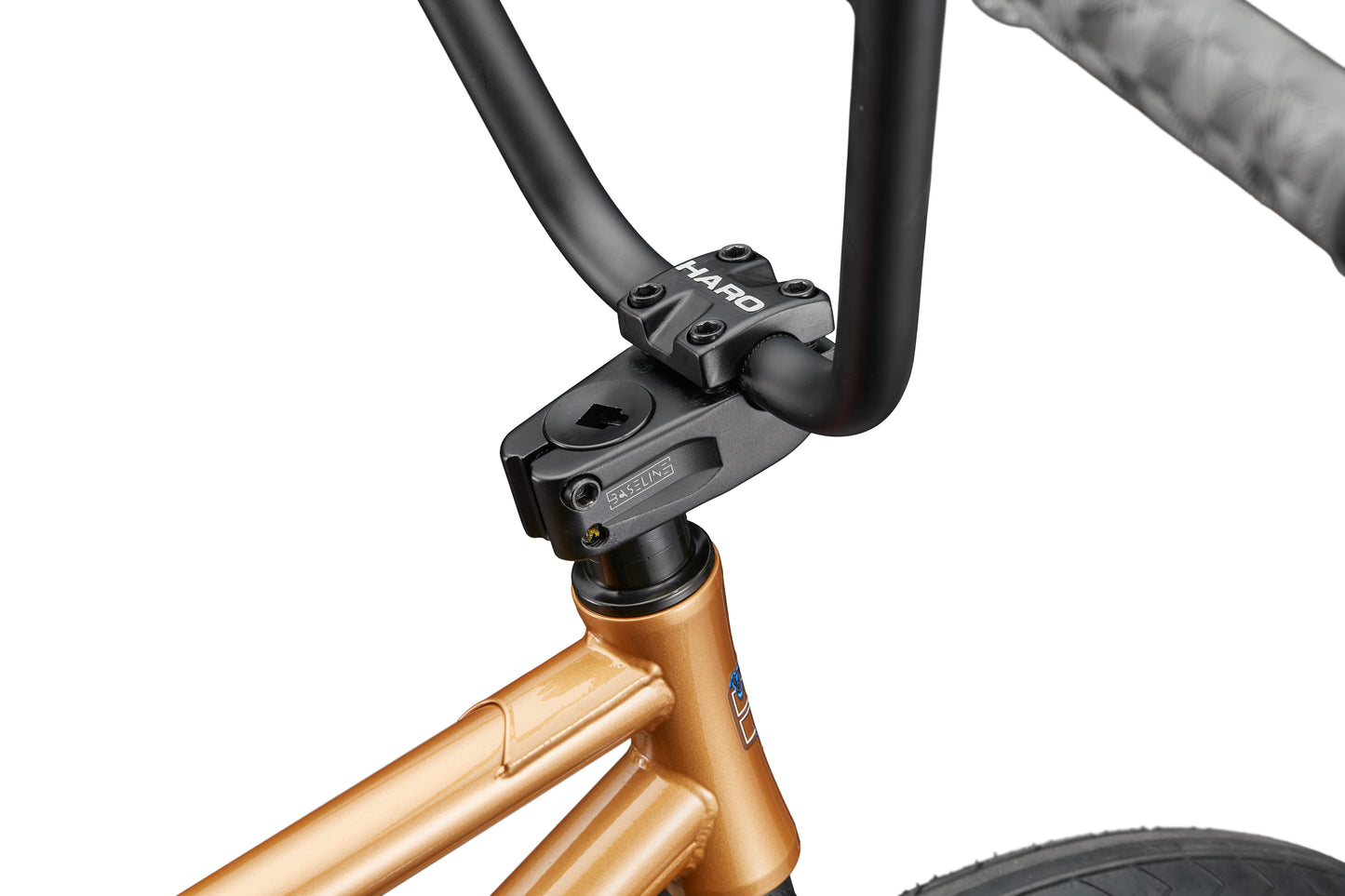Close-up of a black handlebar and stem on a gold Dana street bike frame, set against a white background.