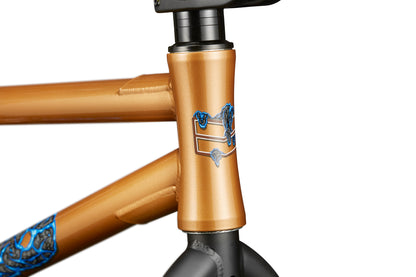 Close-up of Dana bronze bike frame with blue designs, pro-level street performance, and Haro geometry near the handlebar stem.