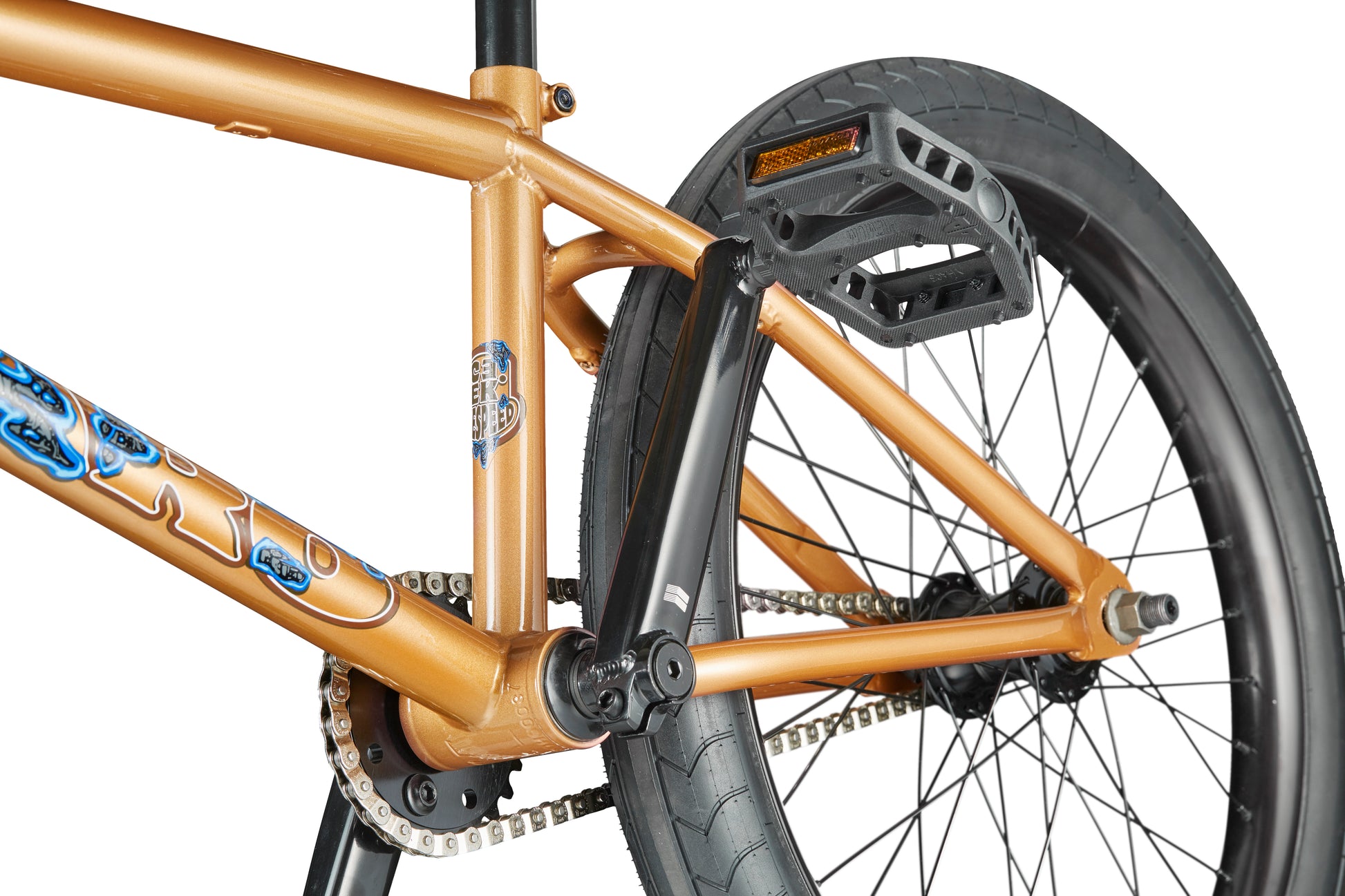 Close-up of the Dana's rear wheel, pedals, and chain—bronze BMX bike with black tires, blue graphics, pro-level street performance.