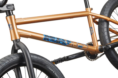 Close-up of the Dana bronze Haro street bike frame with black wheels and blue graphics, built for pro-level performance.