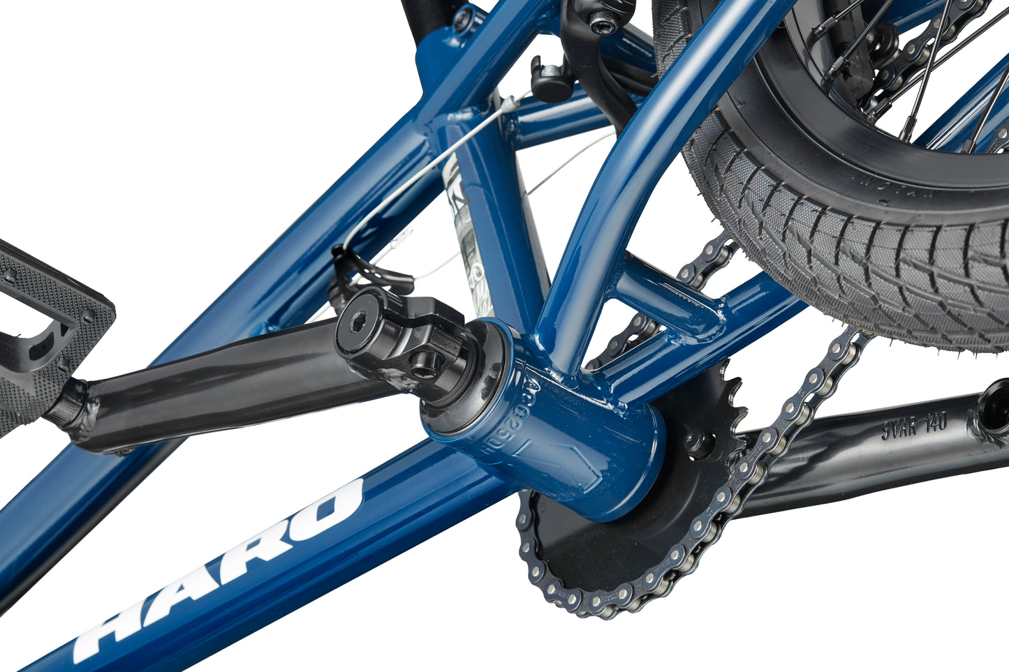 Close-up of a blue Downtown 16 BMX crankset, pedal, and chain, showing frame details and rear tire.