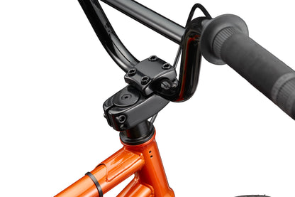 Close-up of the Downtown 16 showing its black handlebar and orange BMX frame, focusing on the stem and upper headset area.