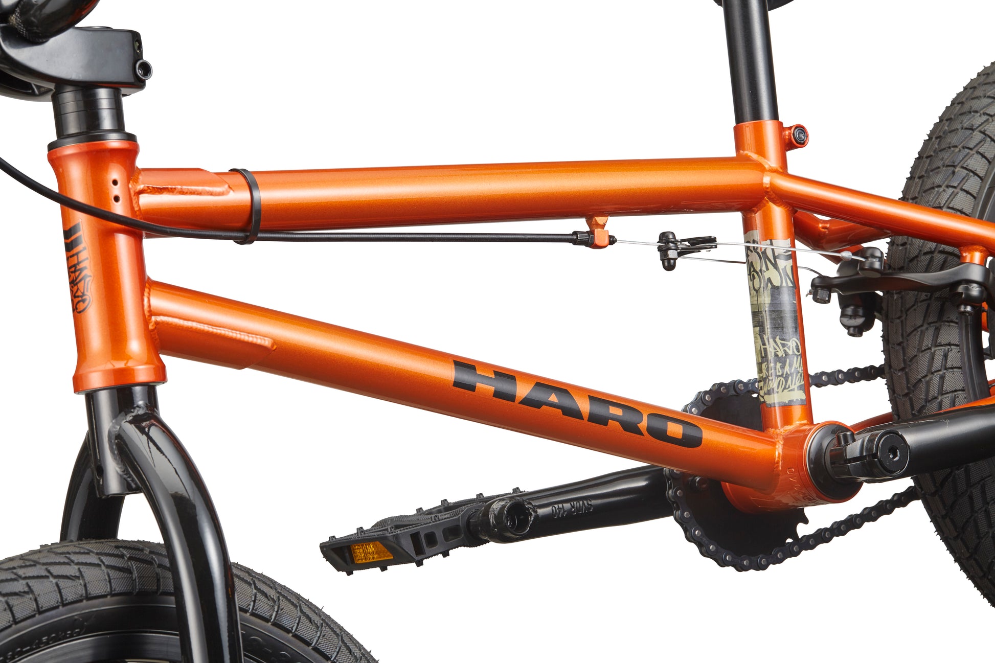 Close-up of a Downtown 16 orange BMX frame with black pedals, tires, and chainring; ideal for young riders against white background.