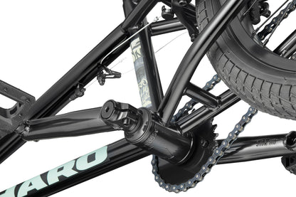 Close-up of the Downtown 18 BMX crank, chain, rear tire, and frame, highlighting the bike's gear mechanism on a white background.