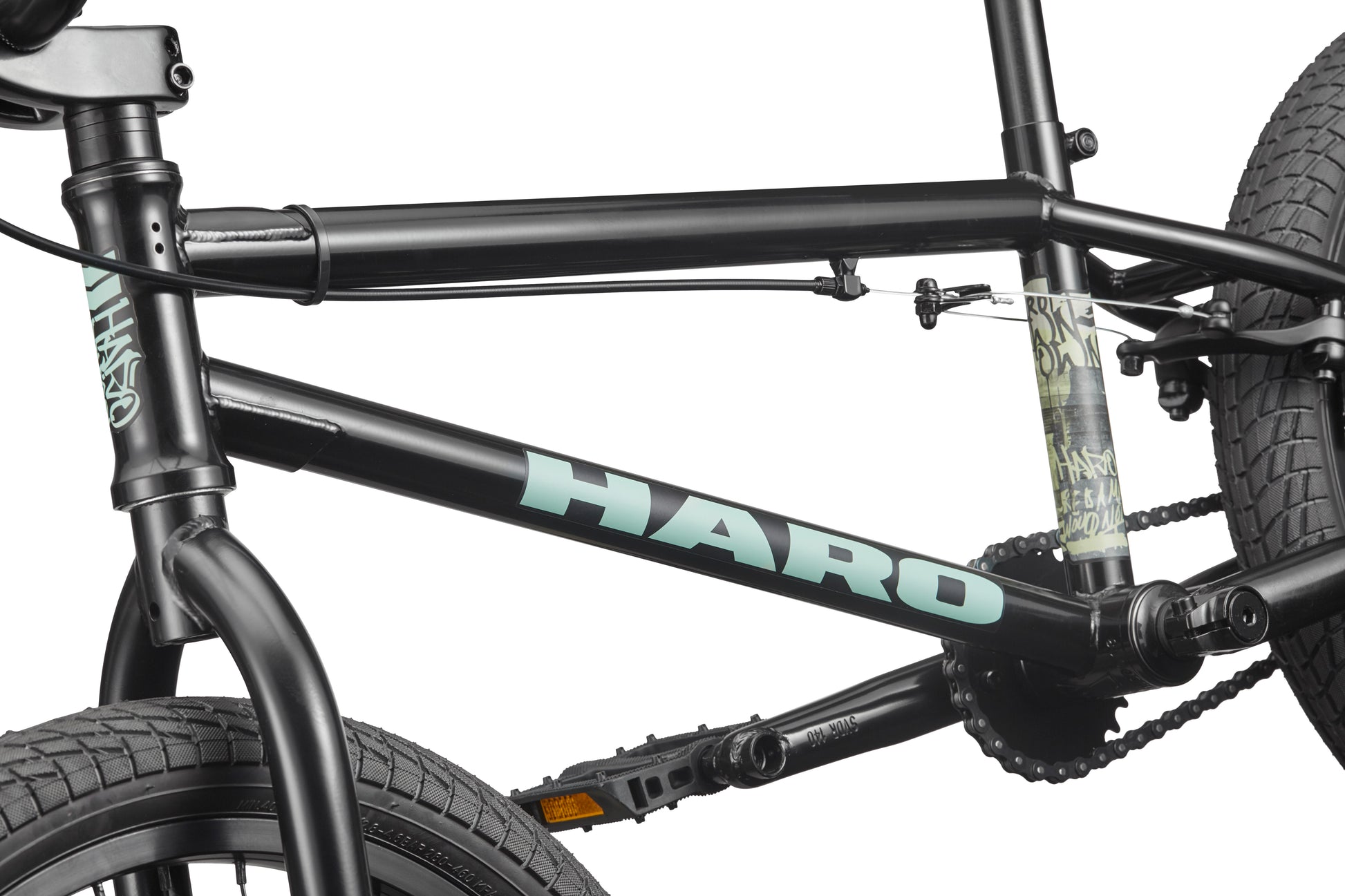 Close-up of the Downtown 18 BMX bike frame, ideal for small riders, showing the front wheel, pedals, chain, and blue HARO logo.