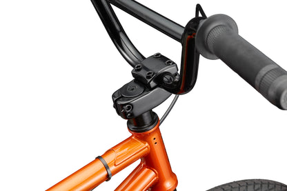 Close-up of a Downtown 18 BMX with black handlebar and stem, orange frame, and front wheel—ideal for small riders.