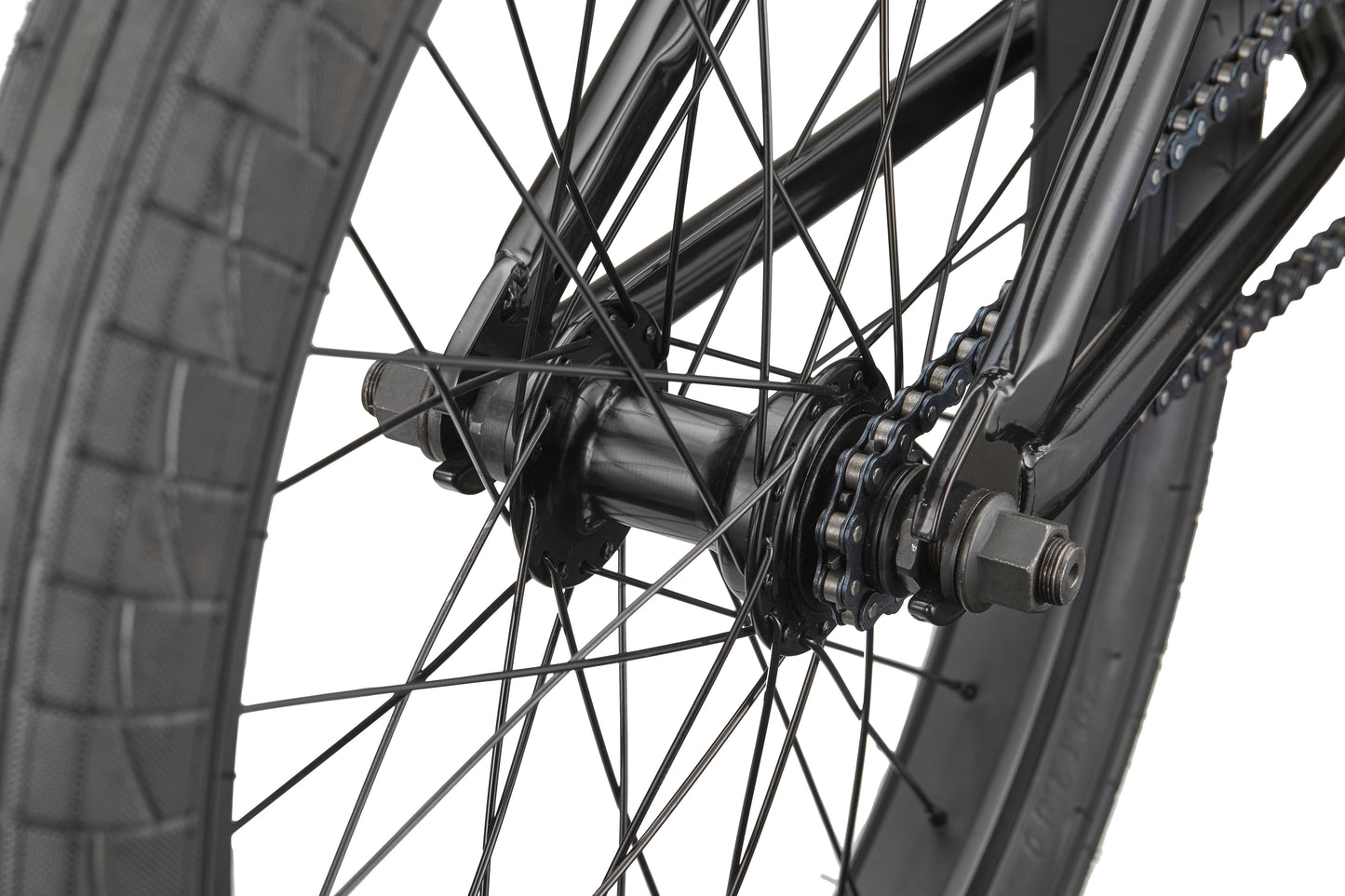Close-up of the Downtown 20 BMX bike’s rear wheel with spokes, chain, and tire—ideal for beginners—against a white background.