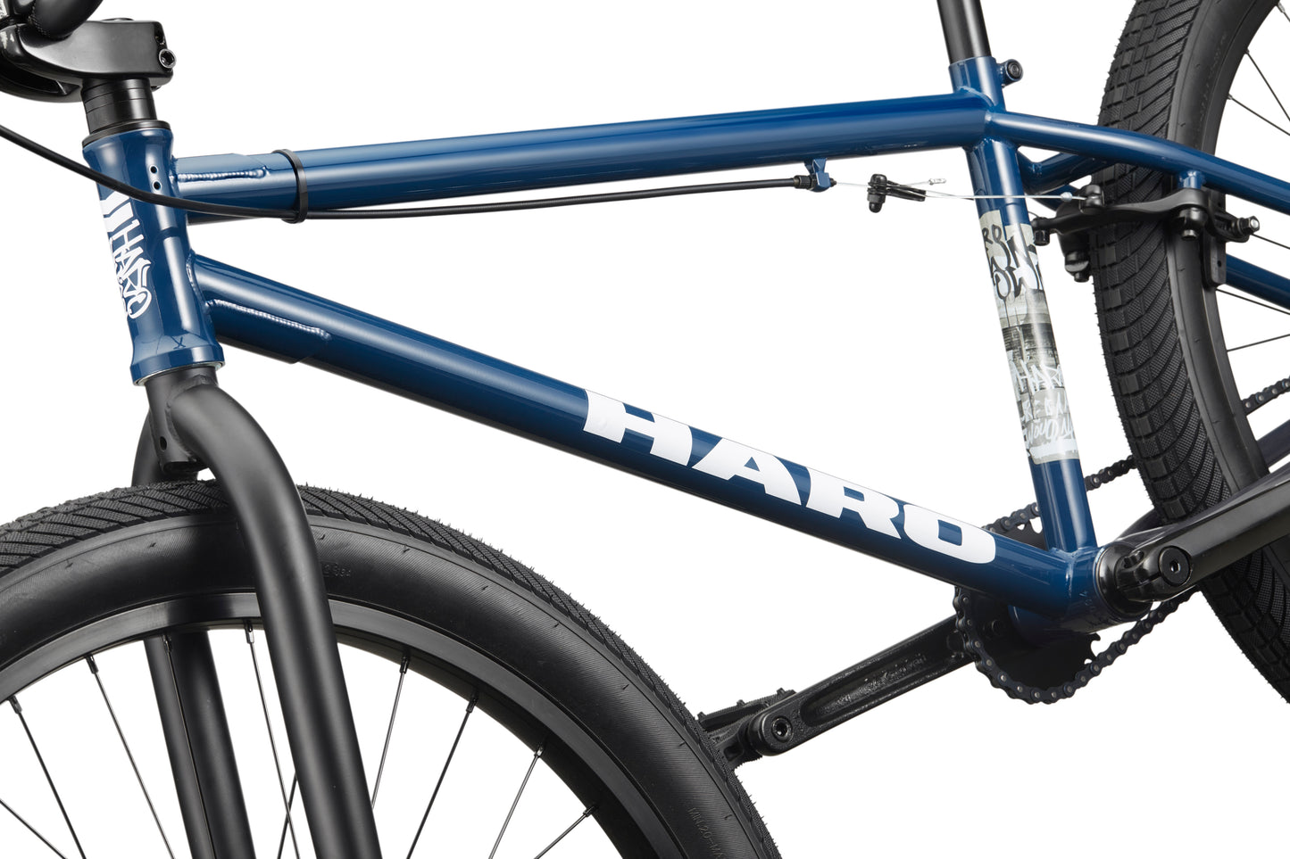 Close-up of a blue Downtown 24 BMX bike frame with 24" wheels, highlighting the tires, spokes, and part of the handlebars.