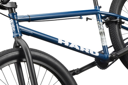 Close-up of a blue Downtown 24 BMX bike frame with 24" wheels, highlighting the tires, spokes, and part of the handlebars.
