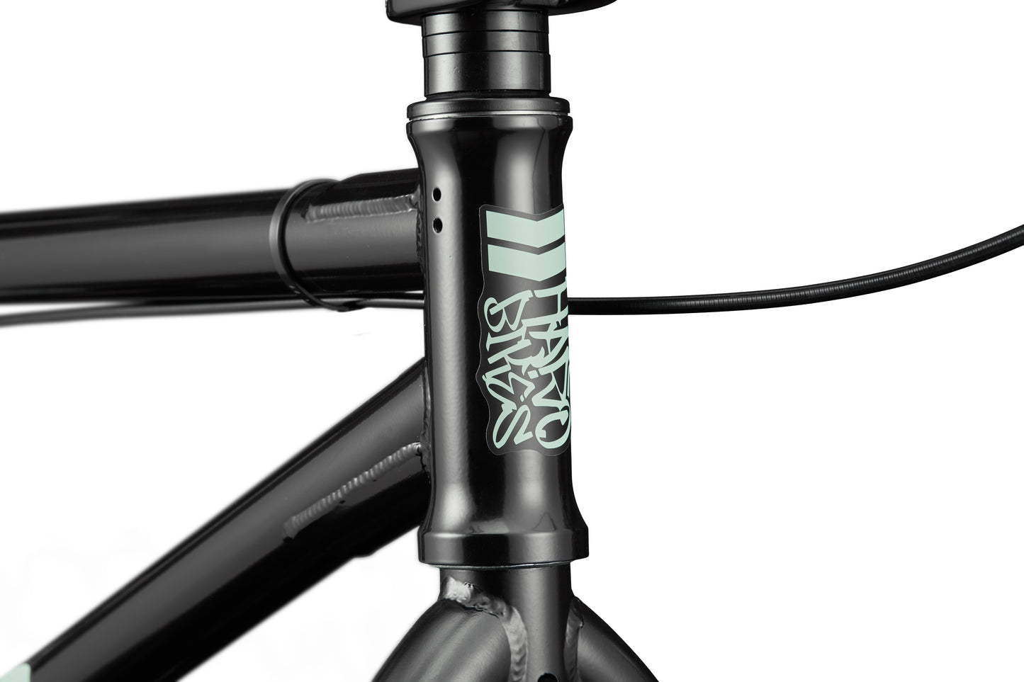Close-up of a black Downtown 24 BMX frame with light blue logo and cables near handlebars, highlighting modern versatility.