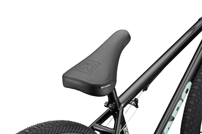 Close-up of a black bike seat on a Downtown 24 BMX frame with 24” wheels, showing modern versatility.