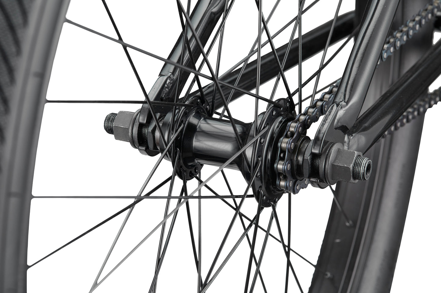 Close-up of a Downtown 24 BMX wheel hub and spokes, highlighting the chain, axle nuts, and frame for modern versatility.