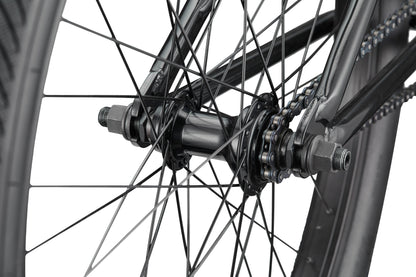 Close-up of a Downtown 24 BMX wheel hub and spokes, highlighting the chain, axle nuts, and frame for modern versatility.
