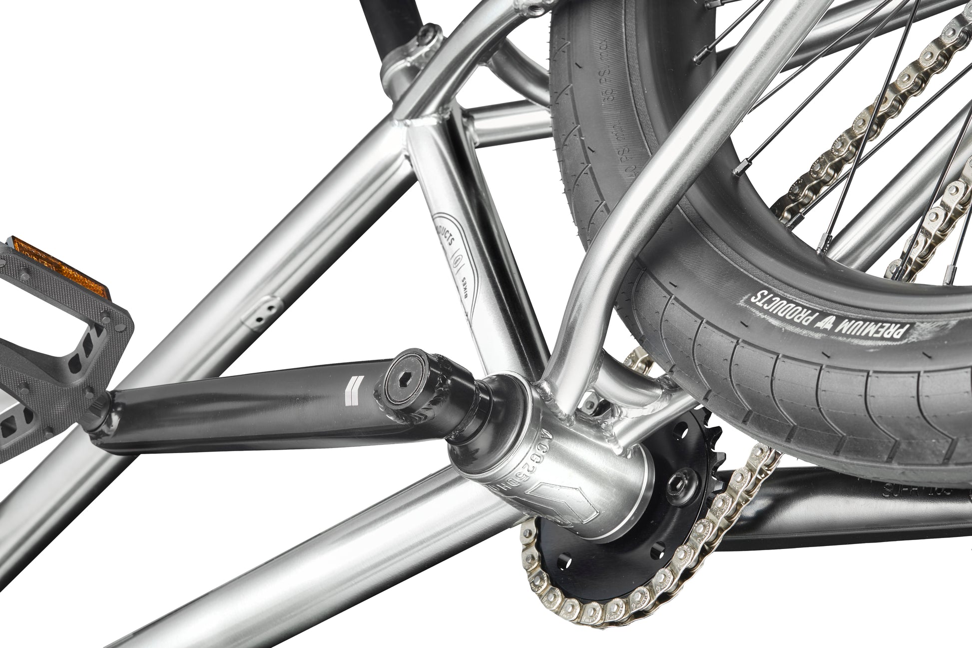 Close-up of a Hoover BMX bike’s rear wheel, chain, pedal, and silver frame, focusing on the crank and tire tread.