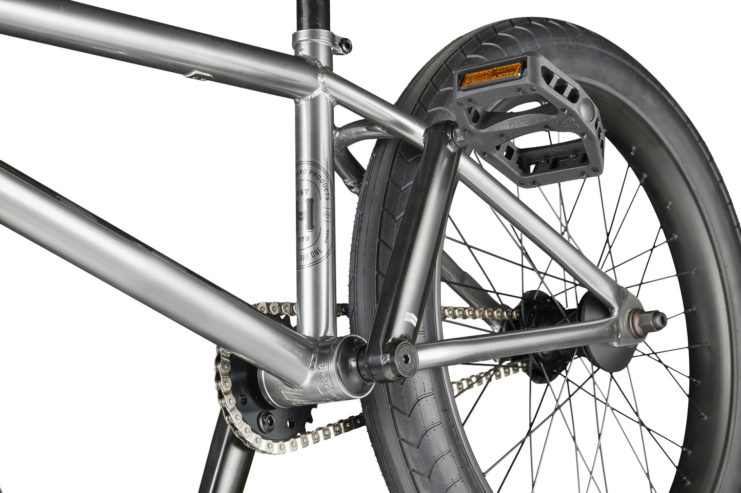 Close-up of a Hoover bike’s rear wheel, pedal, chain, and metal frame on a white background.