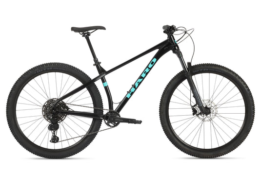 The Double Peak 1 is a black mountain bike with blue HARO lettering, thick tires, Shimano disc brakes, Rock Shox Judy fork, and a straight handlebar.