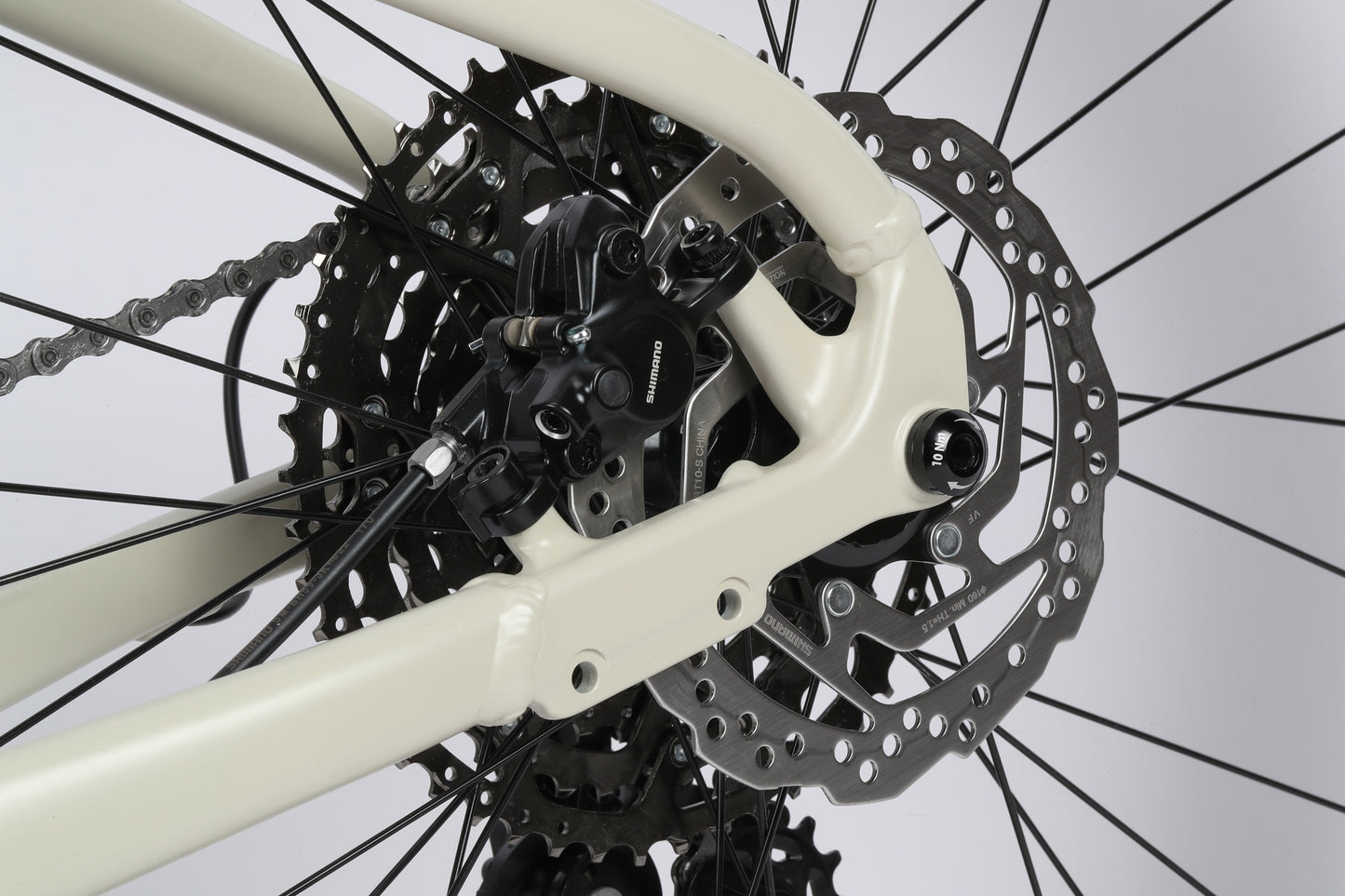 Close-up of a Double Peak 1s Shimano hydraulic disc brakes and gear cassette, highlighting detailed components and mechanisms.