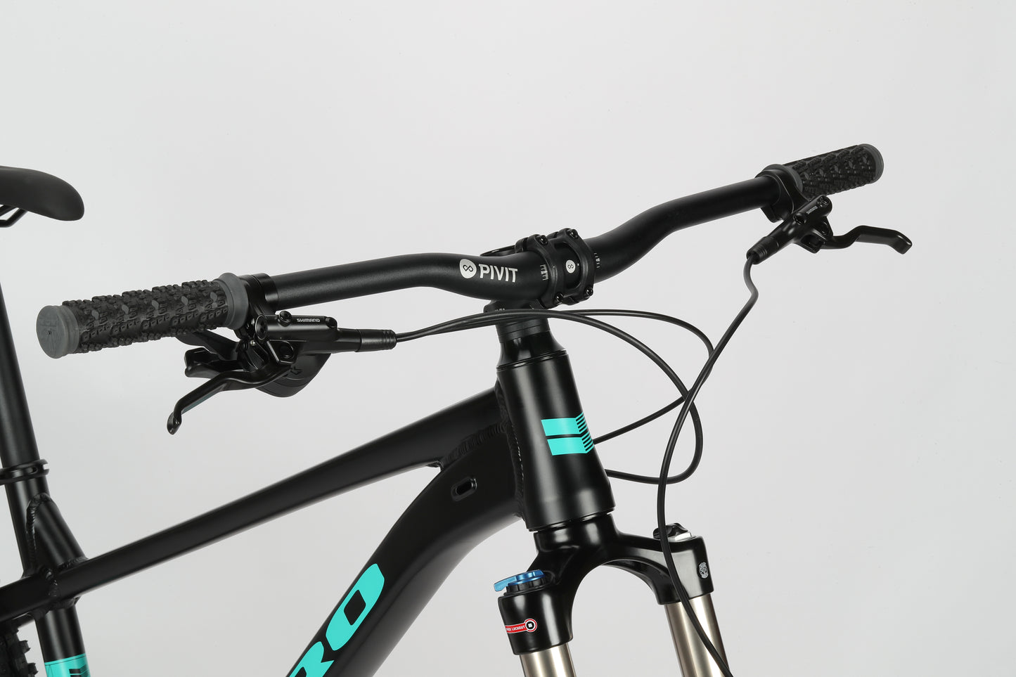 Close-up of Double Peak 2s black handlebars and SR Suntour fork against a white background.