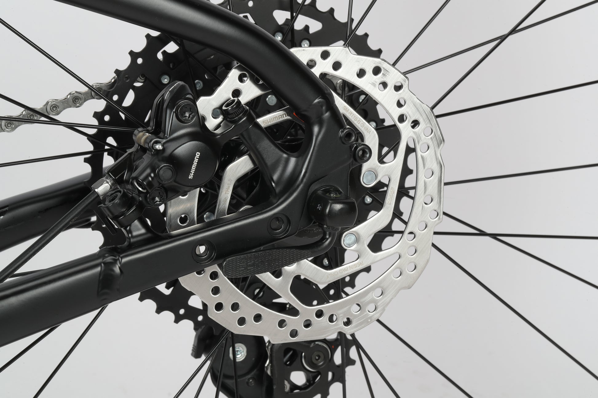 A close-up of Double Peak 2s gear system with SR Suntour fork, intricate black spokes on a white background.