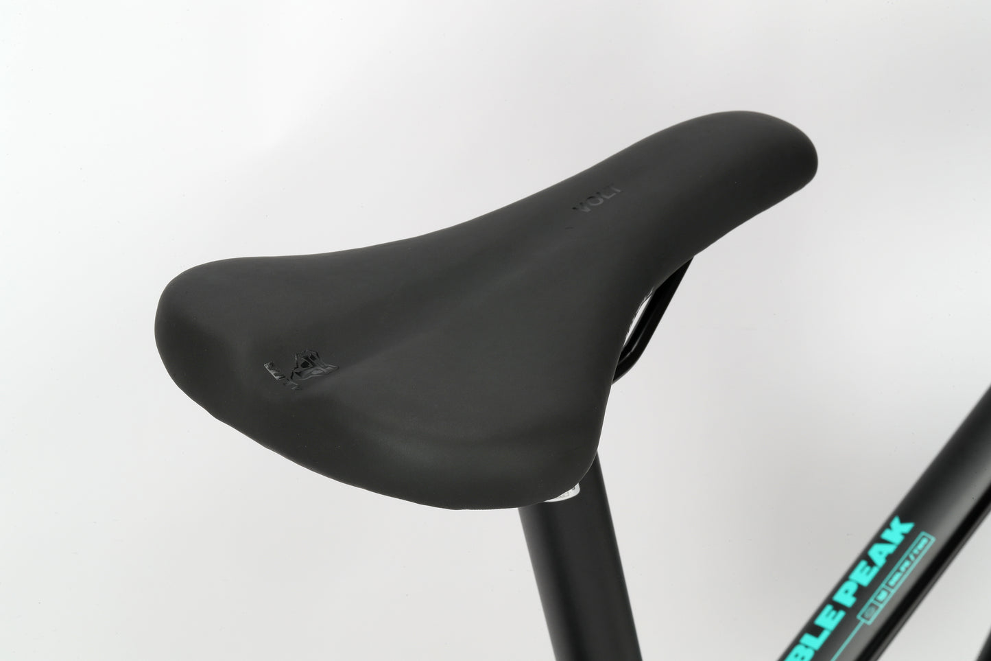 Close-up of the Double Peak 2s black seat with a left-side tear, attached to an aluminum frame with partial branding visible.