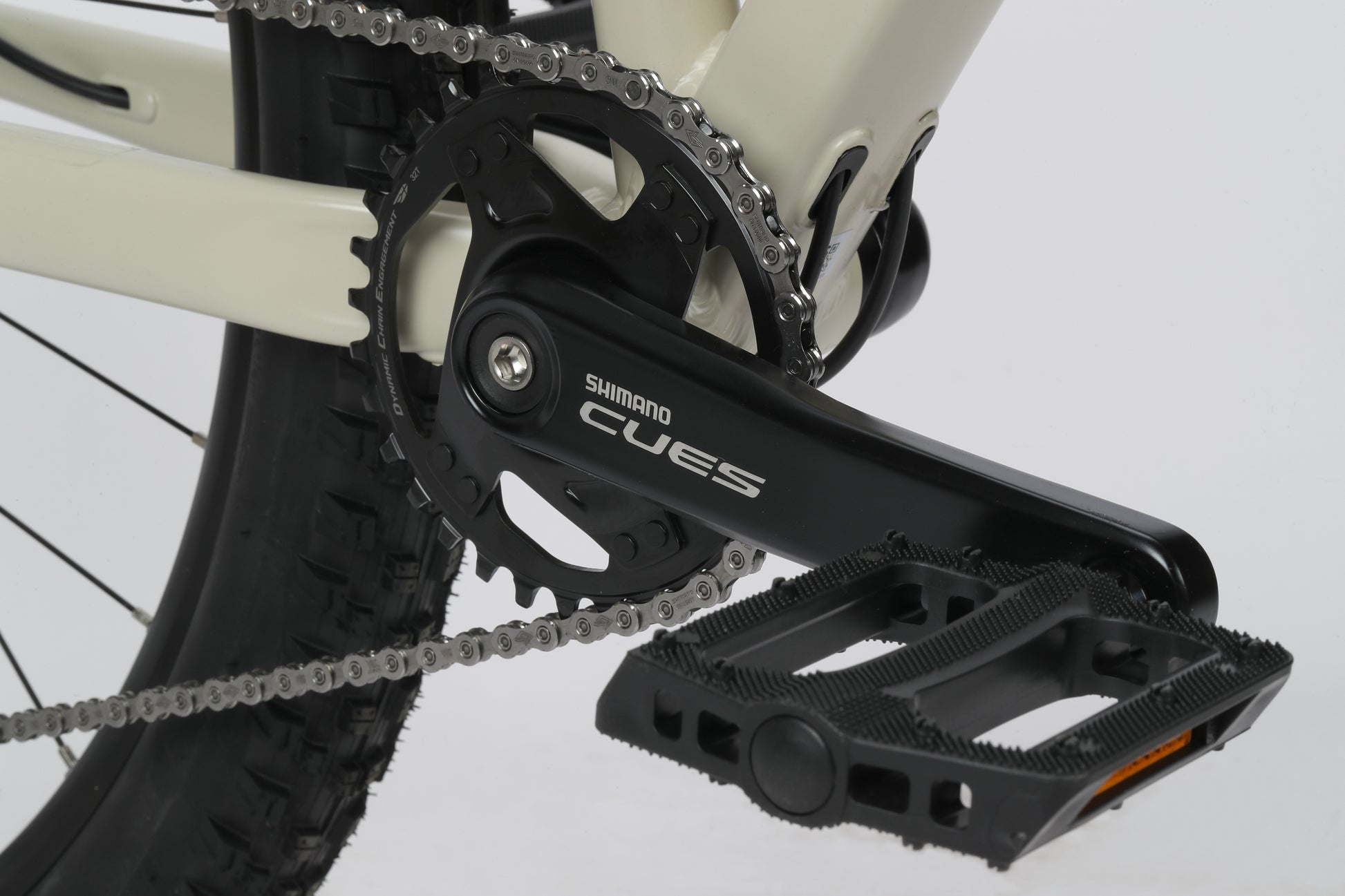 Close-up of Double Peak 2s crankset: Black Shimano Cues crank arm, chainring, pedal, and chain.