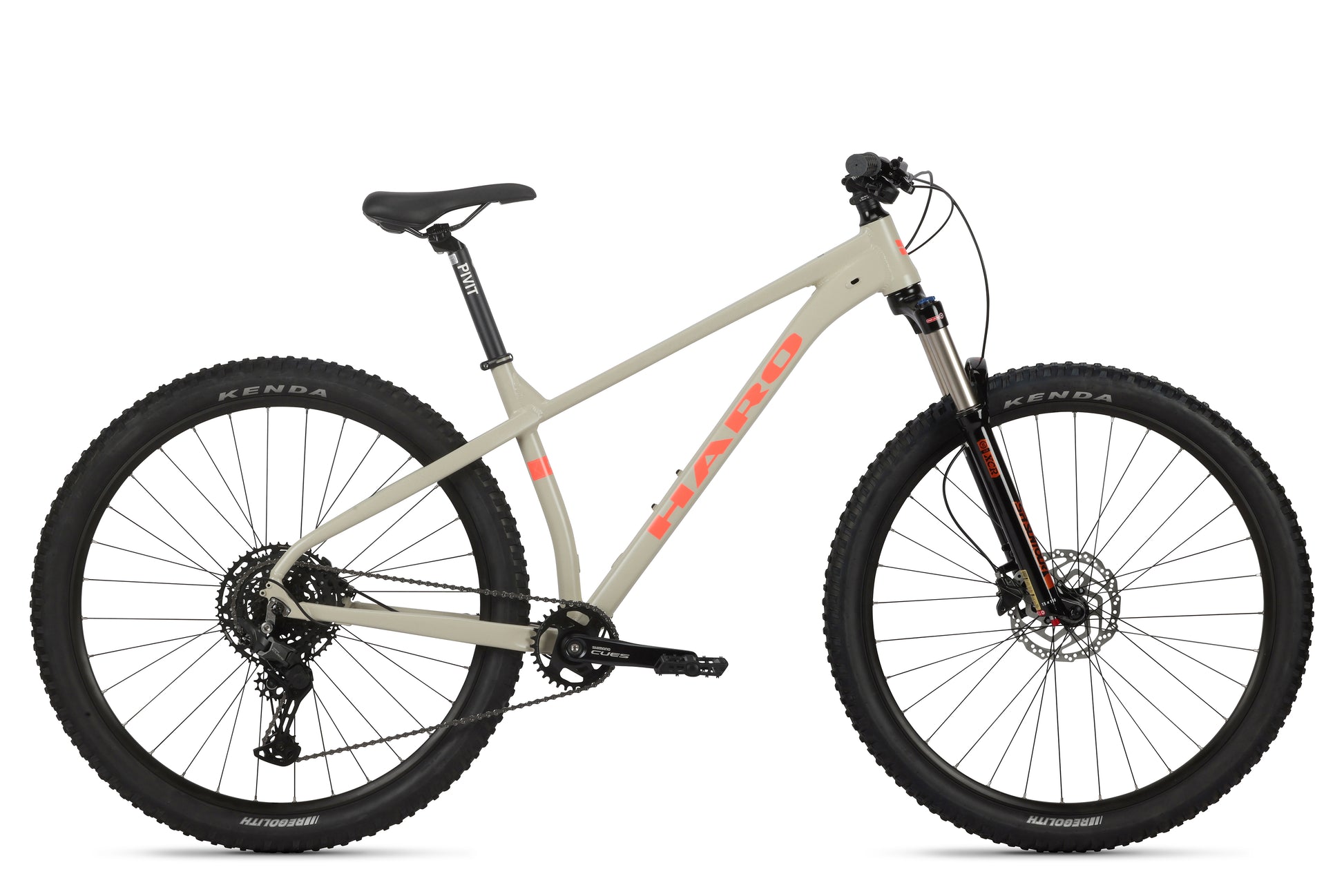 Tan Double Peak 2 mountain bike with HARO on the aluminum frame, SR Suntour fork, large black tires, and disc brakes.