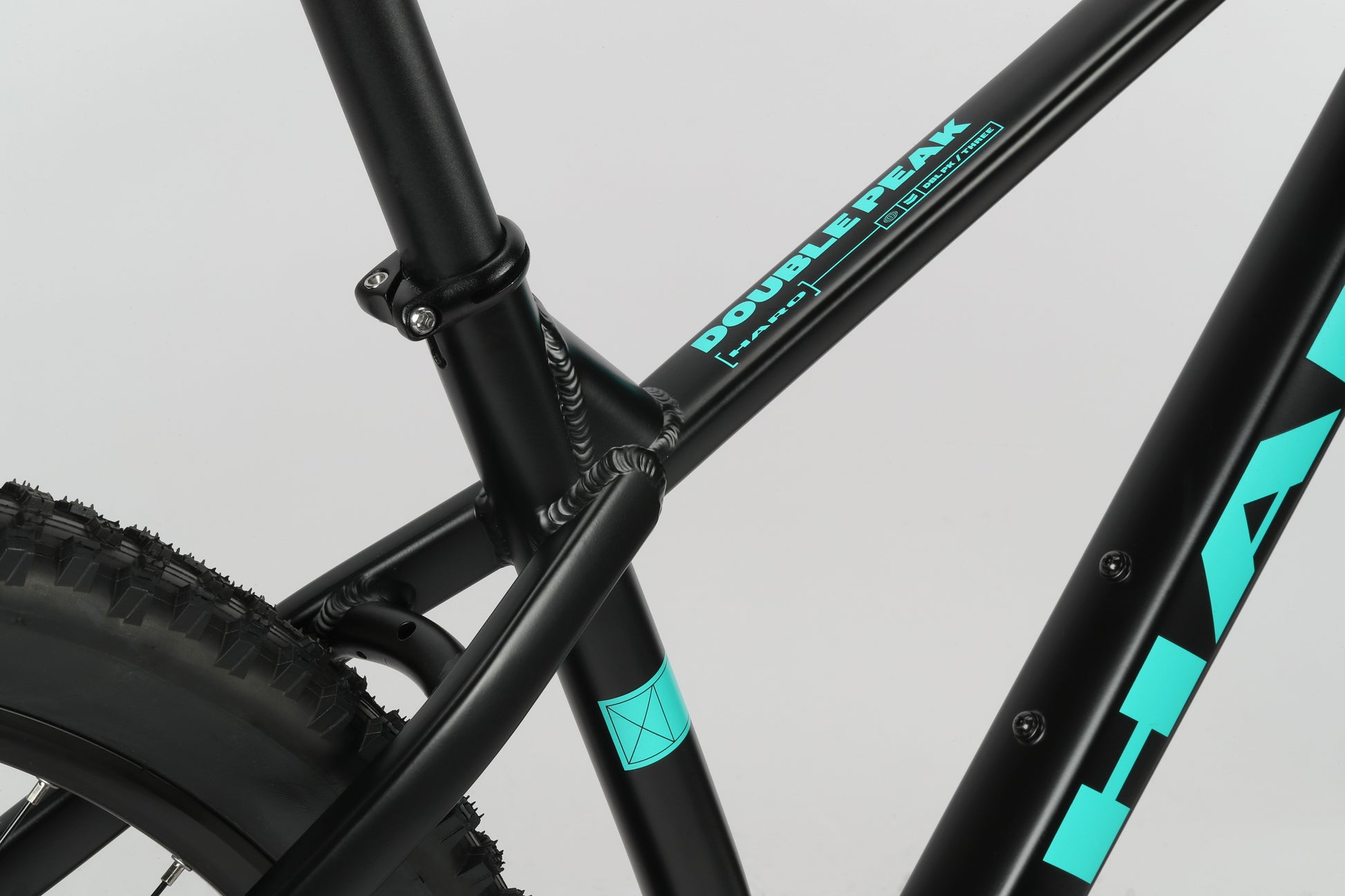 Close-up of a bike frame highlighting the seat tube and tire with Double Peak 3—ideal for your next MTB adventure.