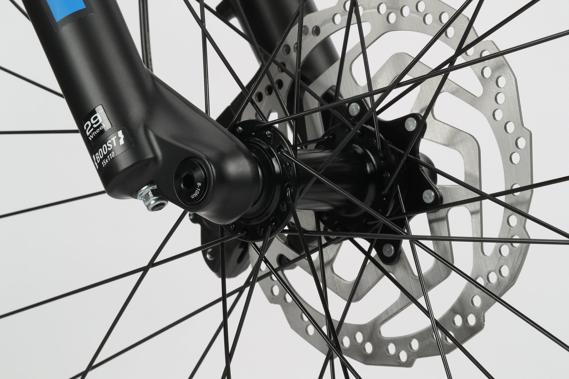 Close-up of a Double Peak 3 bikes front wheel, detailing the disc brake and spokes, ideal for MTB adventures.