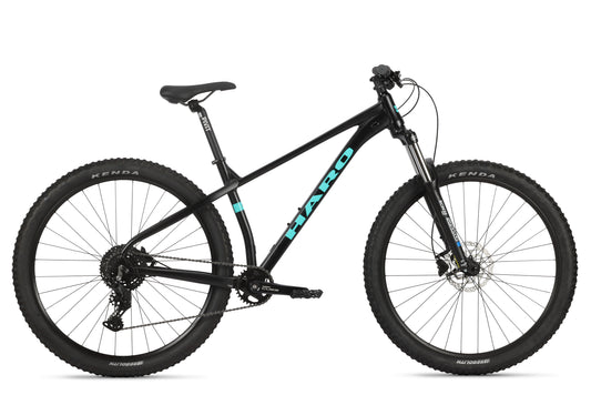 The Double Peak 3 is a black mountain bike with a teal Haro logo, disc brakes, and knobby tires, ideal for affordable MTB adventures.