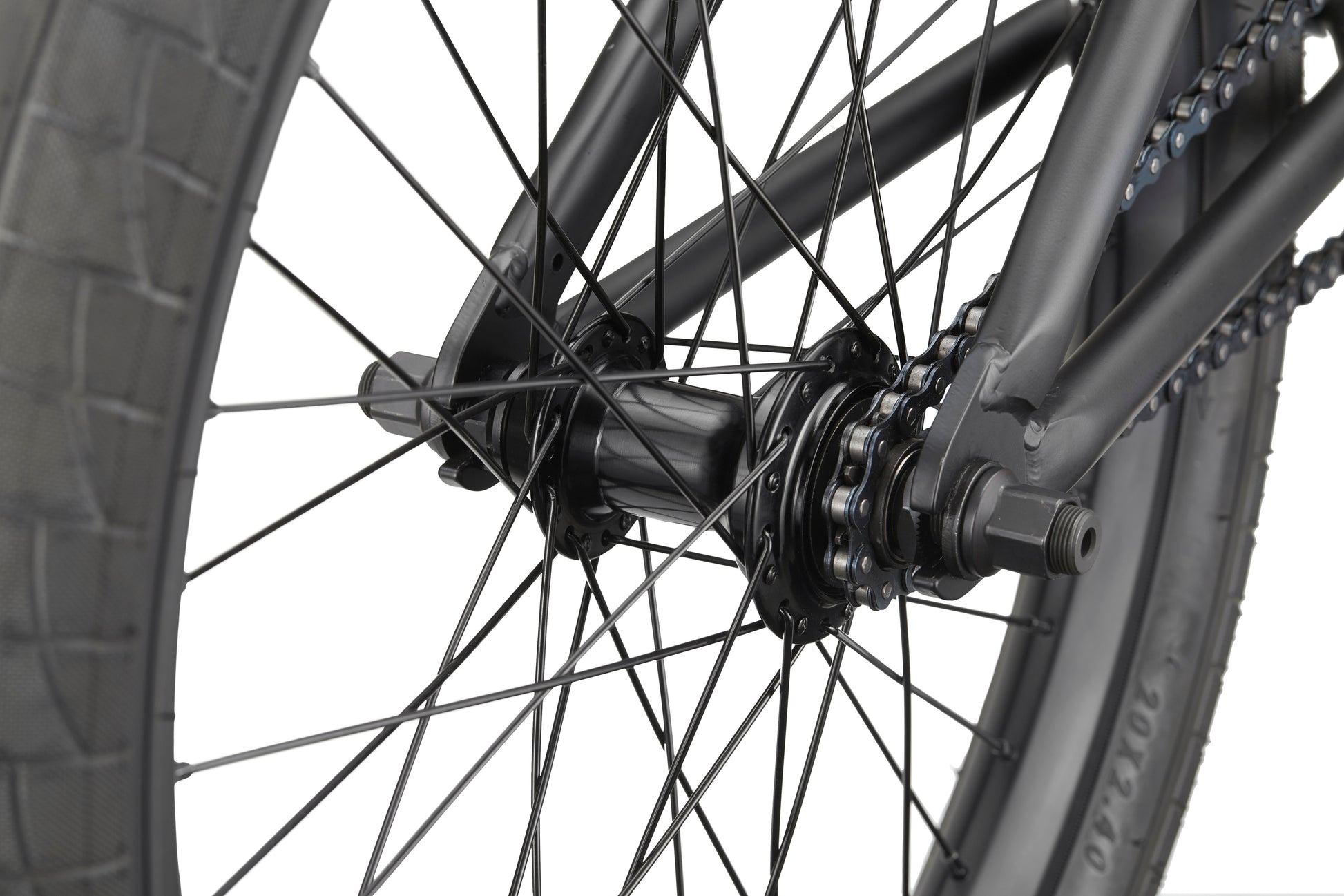 Close-up of the BLVD bike's rear wheel, showing its spokes, tire, hub, axle, and part of the chain.