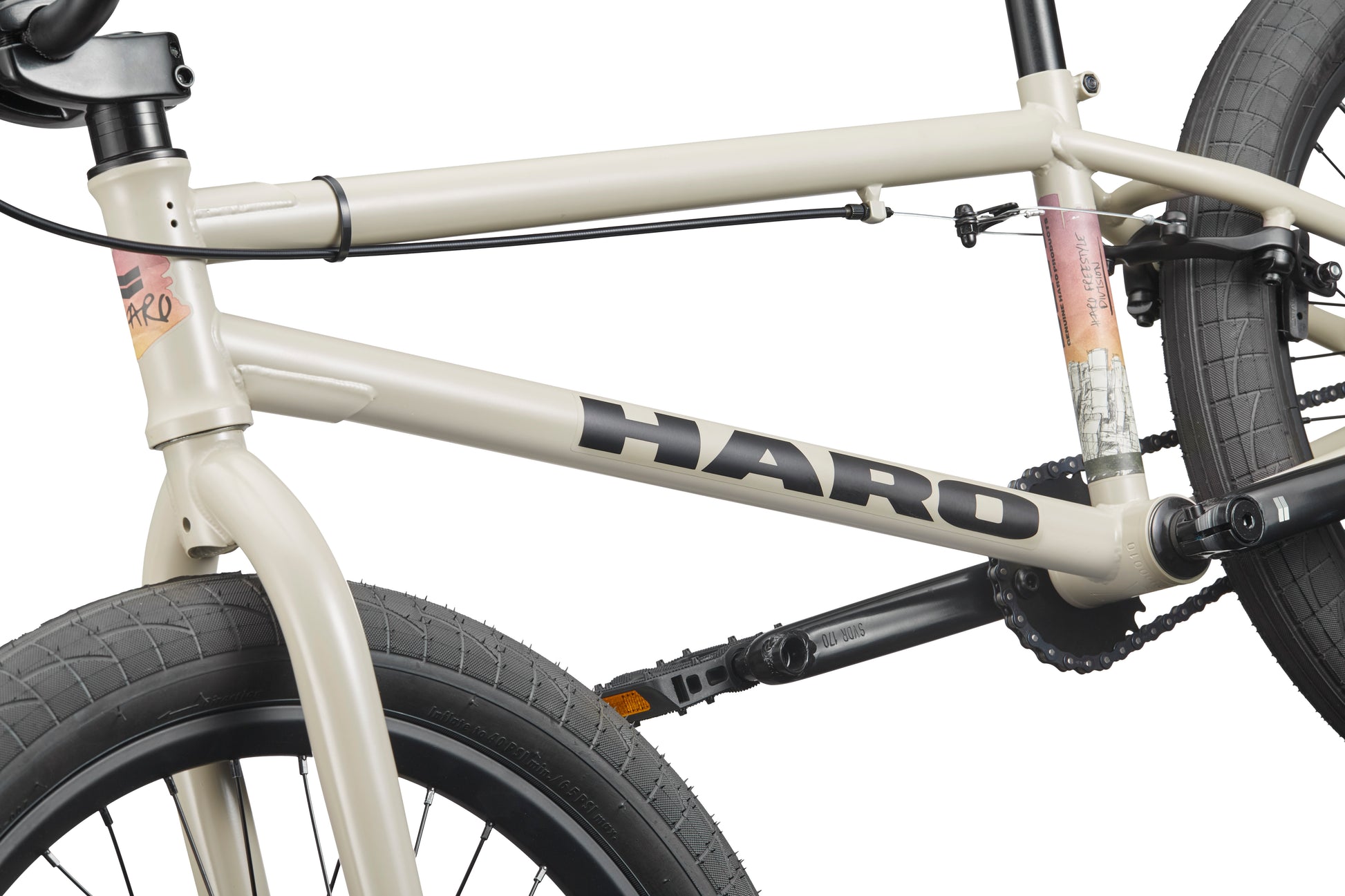 Close-up of a beige BLVD BMX frame, featuring the logo, tires, pedals—highlighting its all-around performance.