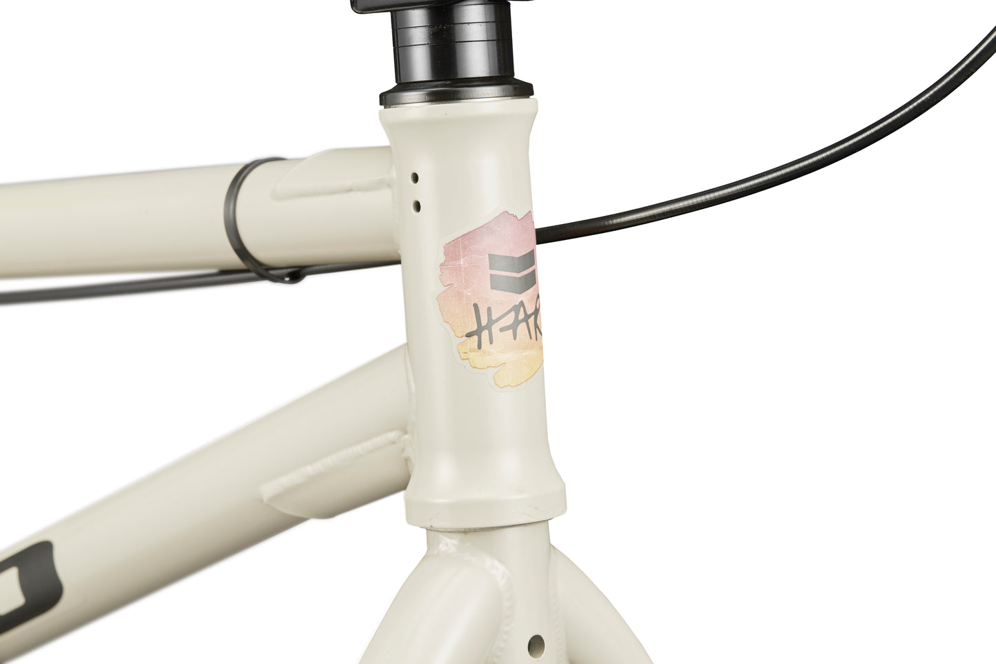 Close-up of a white BLVD bike’s front frame with a colorful HARD logo, highlighting versatile, all-around performance.