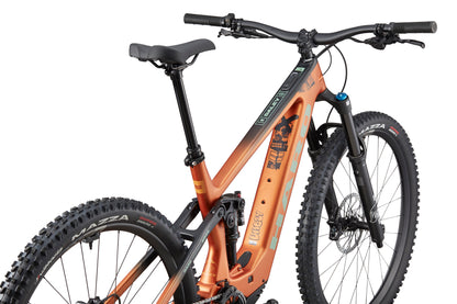 The eDaley Carbon 2, an orange full-suspension mountain bike with thick tires and a Bosch Performance Line SX motor, viewed rear three-quarter.