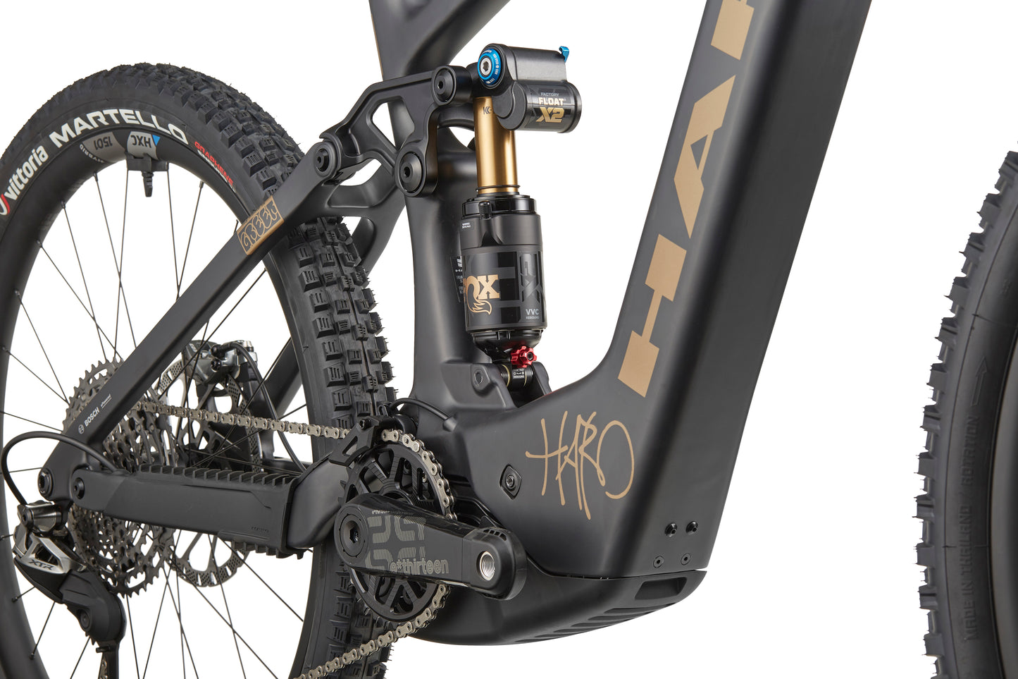 Close-up of a black eGreer Carbon Top Shelf frame showing rear suspension, chain, and rear wheel with Martello tire branding.