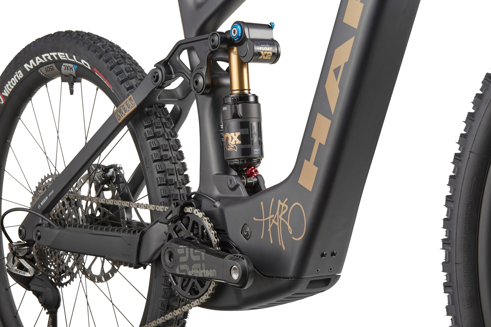 Close-up of a black eGreer Carbon Top Shelf frame showing rear suspension, chain, and rear wheel with Martello tire branding.