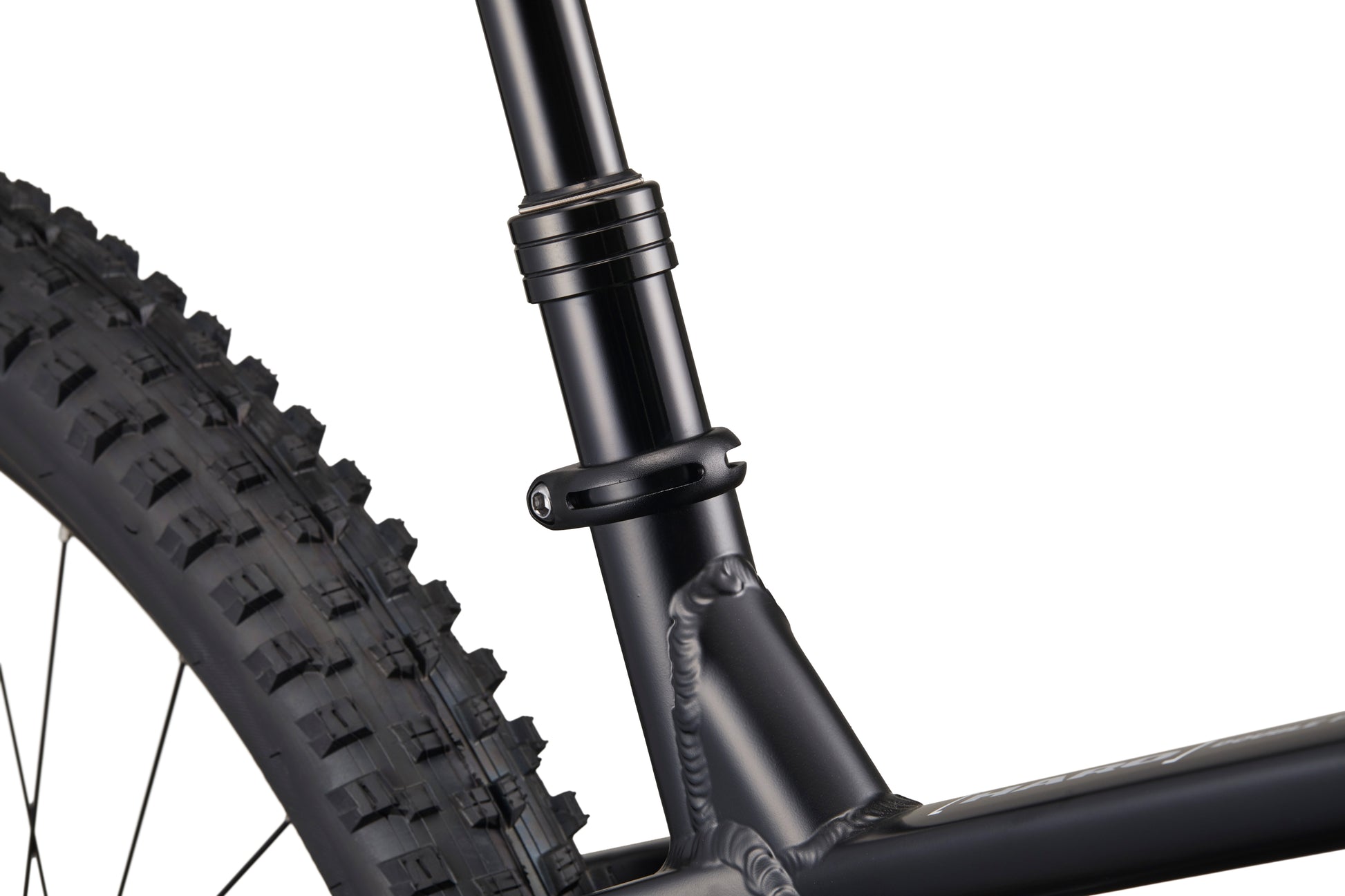 Close-up of Double Peak bike’s seat post clamp, rear tire, and frame with visible welds.