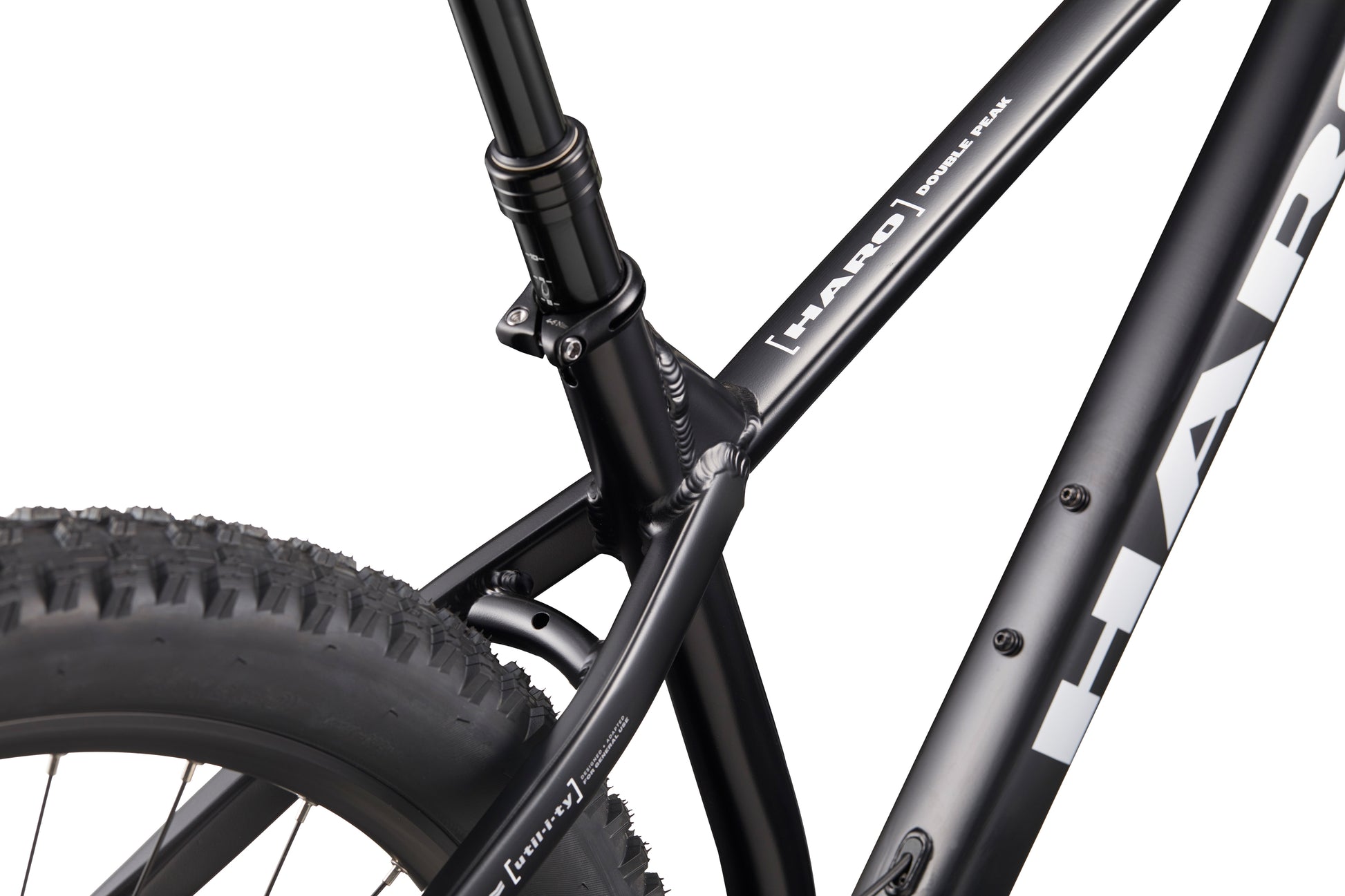 Close-up of Double Peak mountain bike’s black frame, seat tube, rear tire, logos, and hydraulic disk brakes.