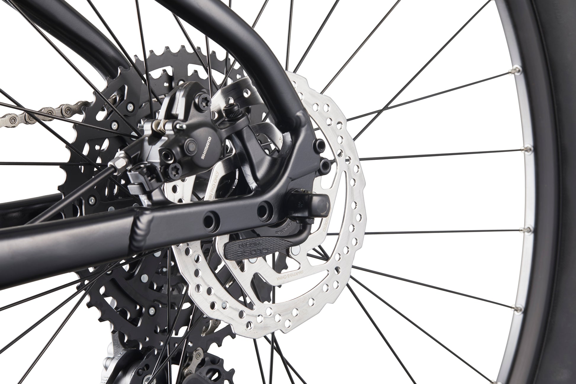 Close-up of Double Peak’s rear wheel, showcasing hydraulic disc brakes, sprockets, and spokes against a white background.