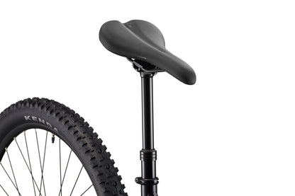 Close-up of Double Peak’s black bike seat, dropper post, seatpost, and rear tire against a white background.