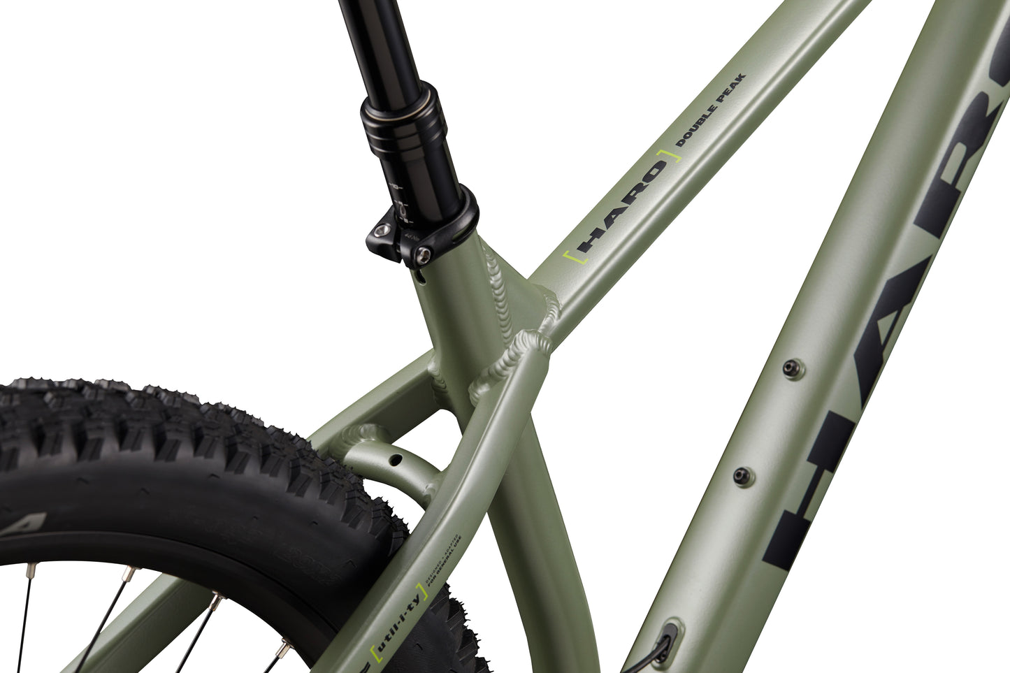 Close-up of a green Double Peak bike frame, rear tire, seat tube, and hydraulic disc brakes are visible.