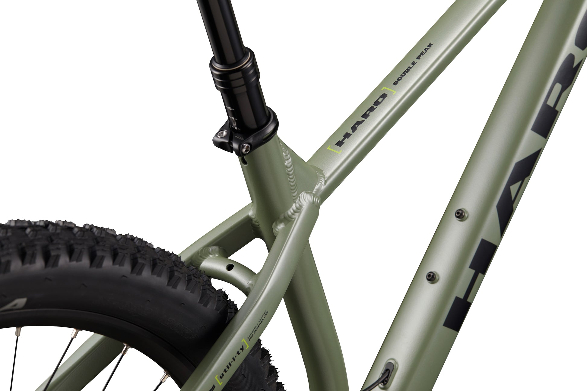 Close-up of a green Double Peak bike frame, rear tire, seat tube, and hydraulic disc brakes are visible.