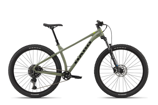 The Double Peak mountain bike, shown side view on white, has thick tires, hydraulic disc brakes, and a black saddle.