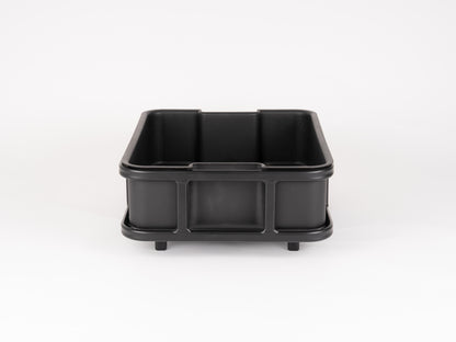 The Bakery Crate by Atran Velo is a large, rectangular black plastic bin with sturdy side handles. Its cargo-style design, smooth surface, and slightly raised edges make it ideal for storage or transport.