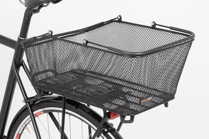 The Atran Velo Daily Basket Large is a seamless, steel mesh basket attached to the rear rack of a black bicycle, ideal for carrying items. It stands out against a white background, complementing the sleek bike frame and rear fender design.