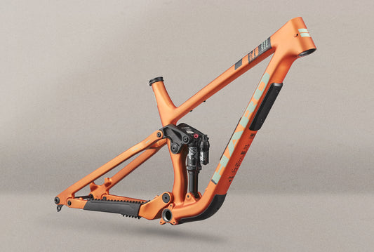Daley Carbon Frameset: full-suspension, all-mountain bike in orange shown side-on against a neutral gray background.